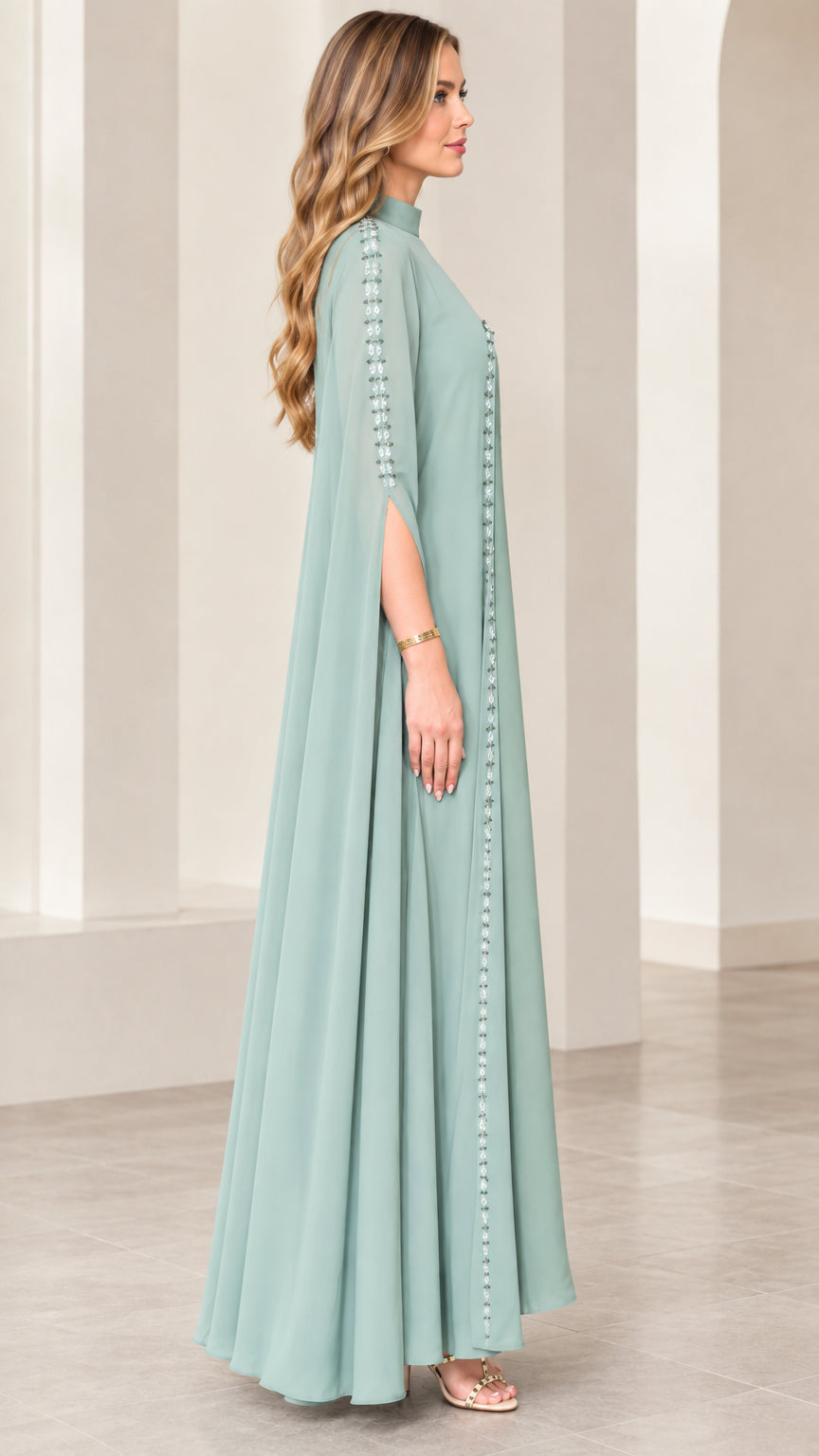 Side angle view of sage green cape sleeve evening gown showing sleeve slit and beaded detail