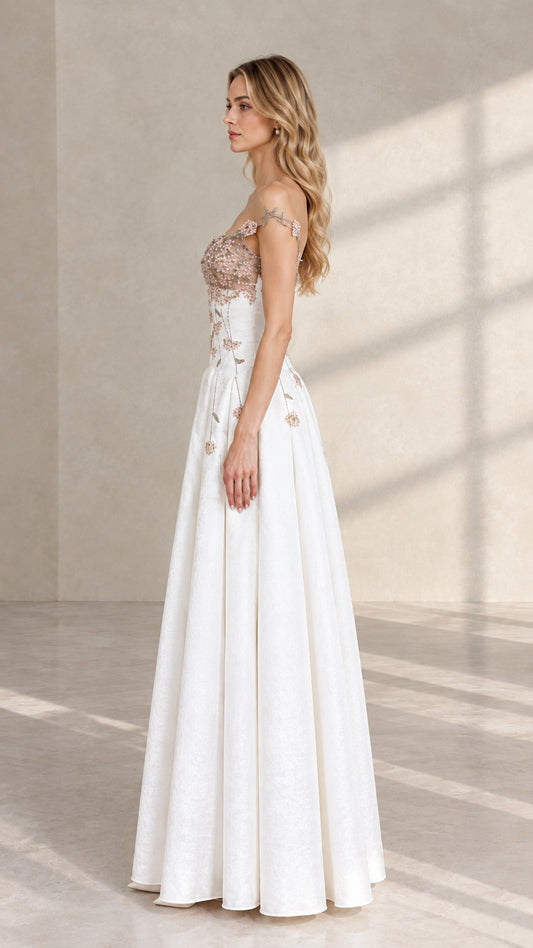 Side profile of white floral embroidered formal gown showcasing fitted bodice and flowing skirt