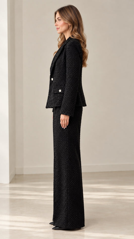 Side profile view of woman wearing black textured tweed pant suit