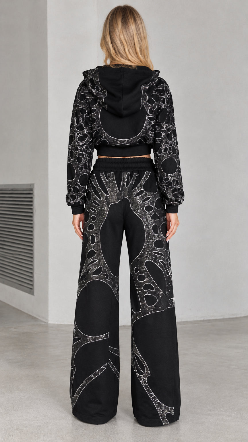 Back view of woman wearing black rhinestone zip hoodie and wide leg pants