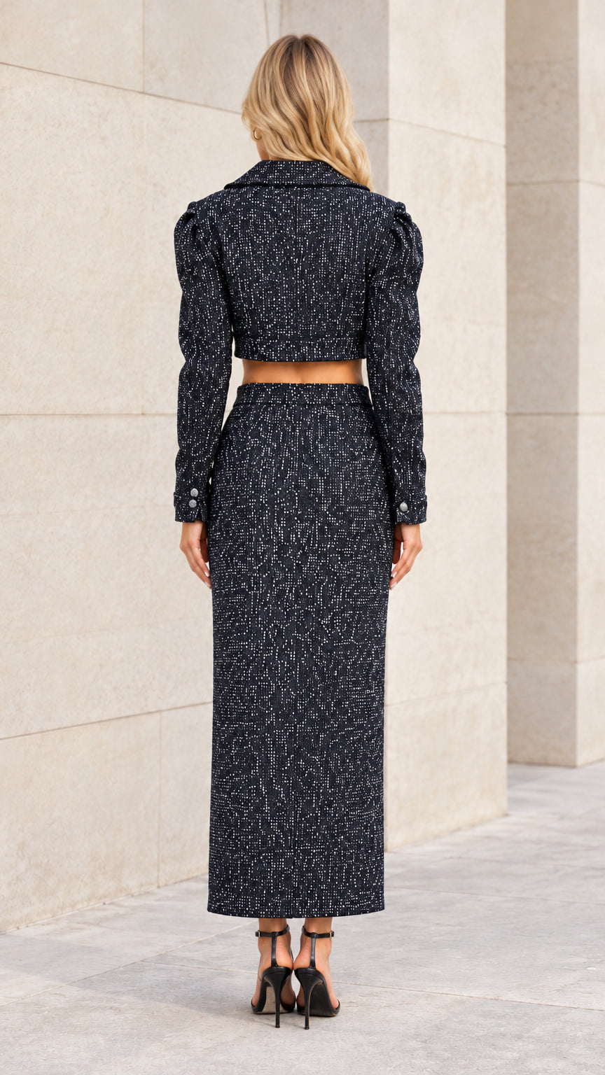 Back view of model wearing black tweed two-piece cropped blazer and skirt set