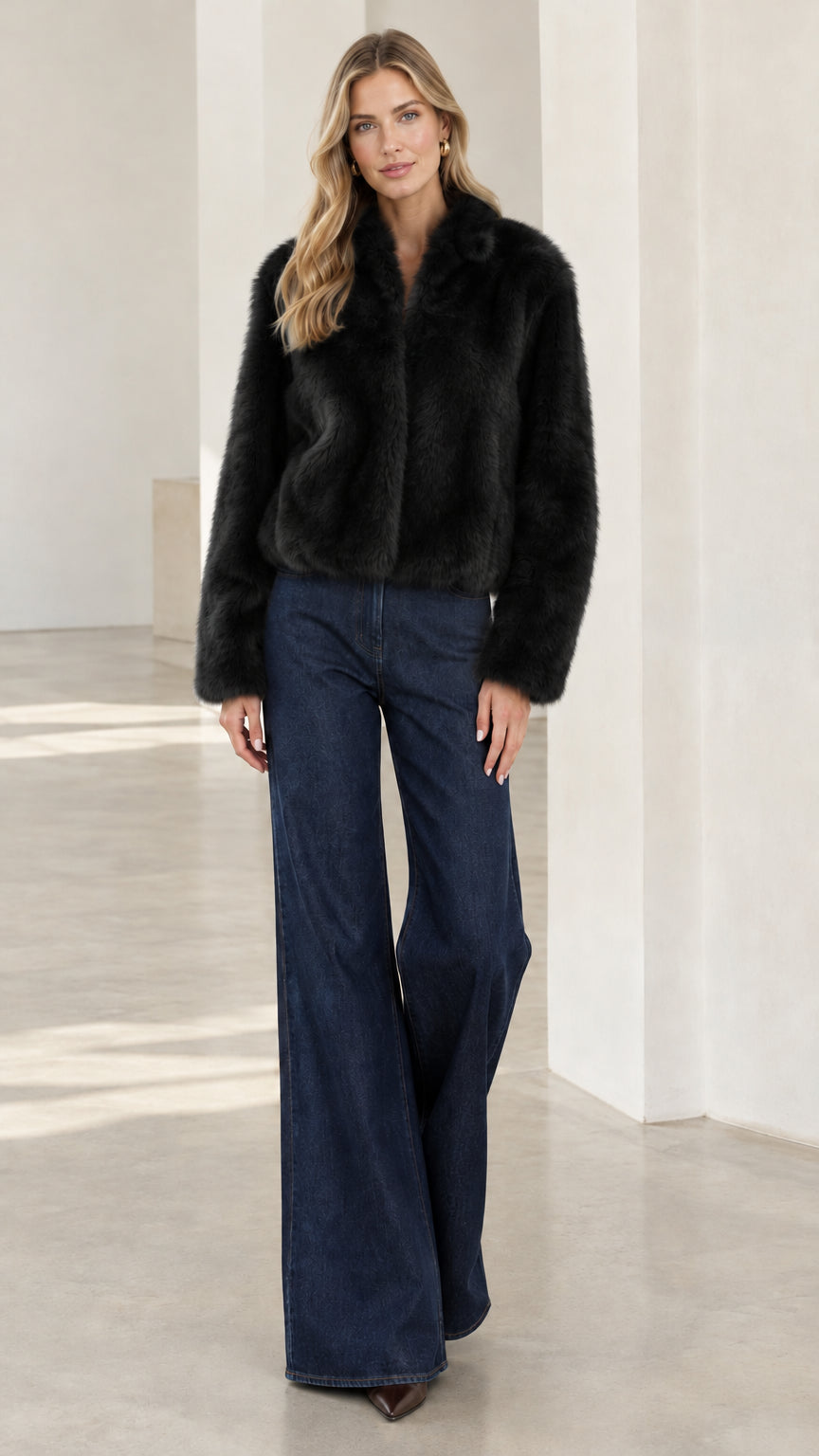Model wearing black cropped faux fur jacket with wide-leg denim