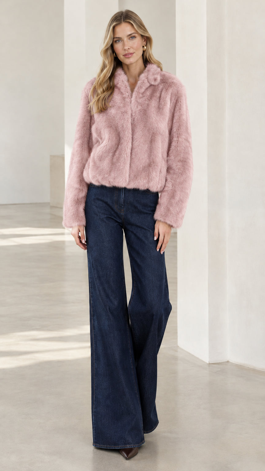 Model wearing dusty pink cropped faux fur jacket with dark jeans