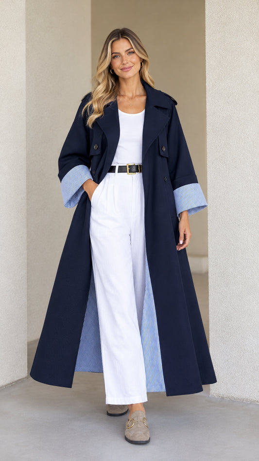 Front view of model wearing Navy Blue maxi trench duster coat with striped cuffs and white pants
