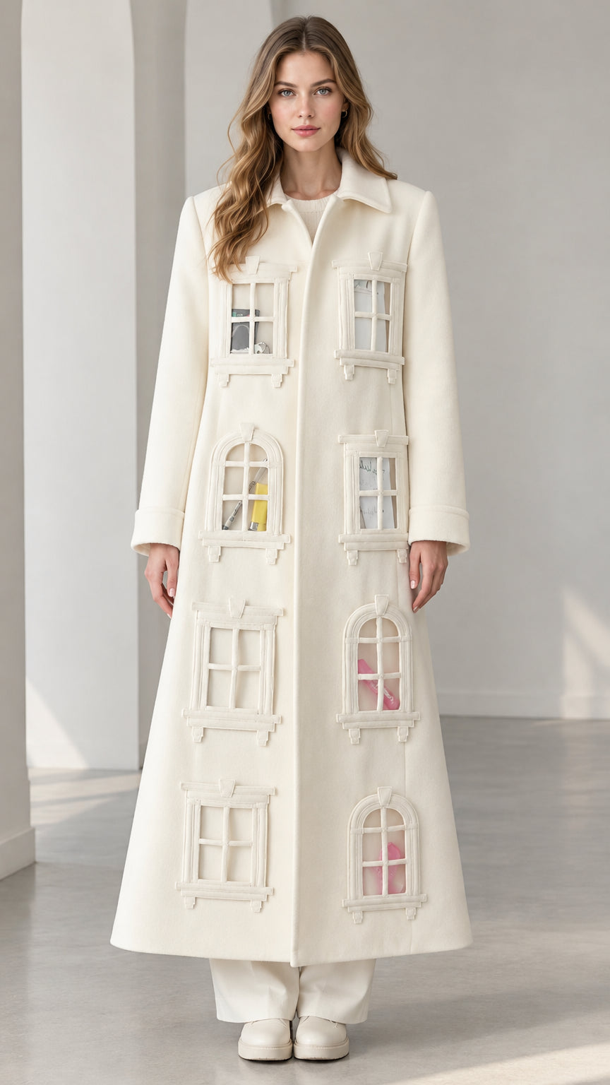 Full-length front view of model wearing ivory architectural window appliqué maxi coat