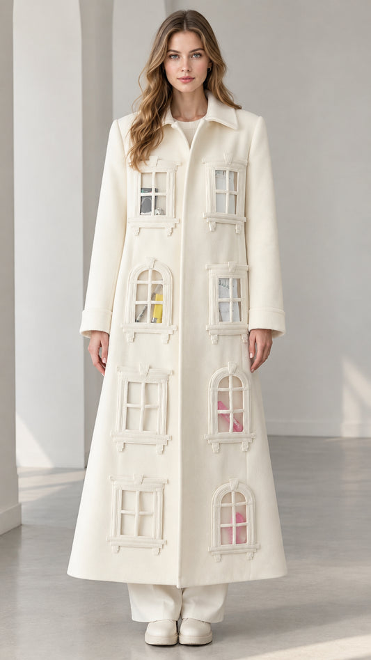 Full-length front view of model wearing ivory architectural window appliqué maxi coat