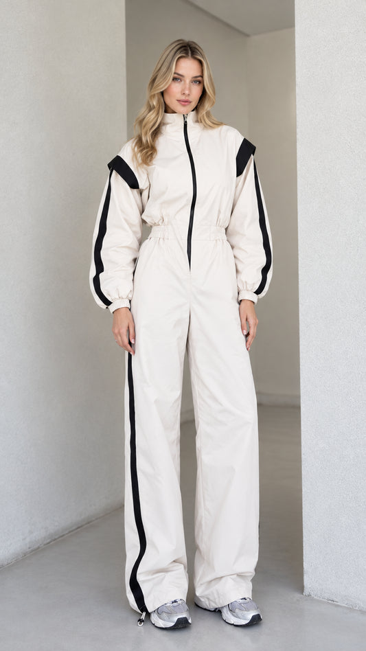 Full front view of women's cream sporty track jumpsuit with black side stripes