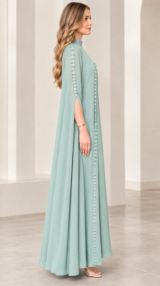 Side angle view of sage green cape sleeve evening gown showing sleeve slit and beaded detail
