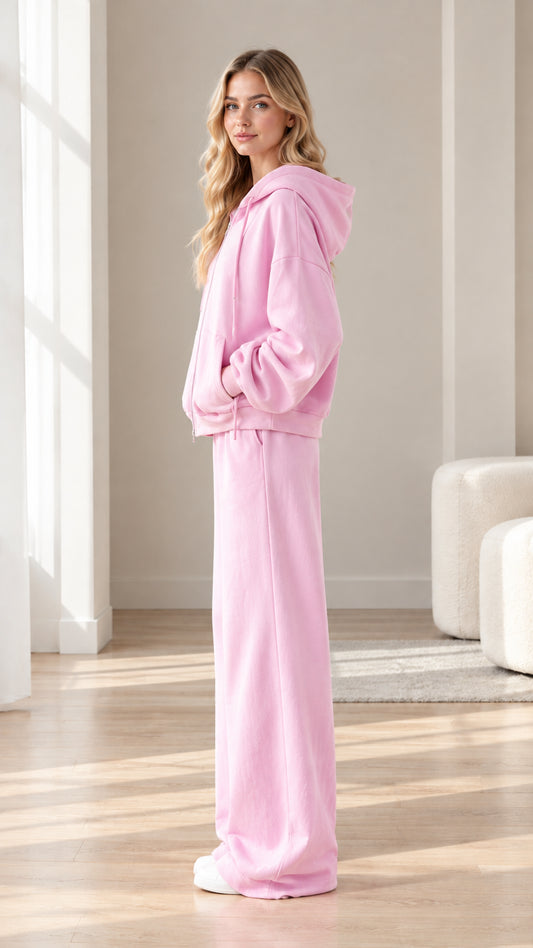 Side profile view of woman wearing pink fleece hoodie and matching wide-leg pants