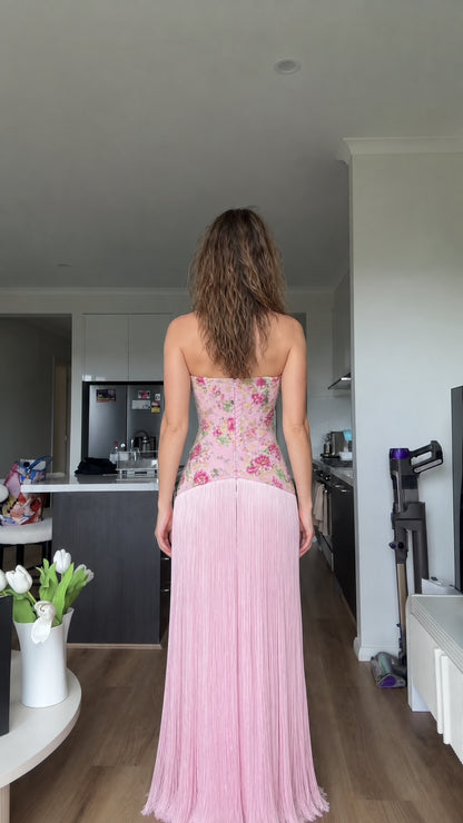 Back view of woman wearing blush pink strapless fringe maxi dress