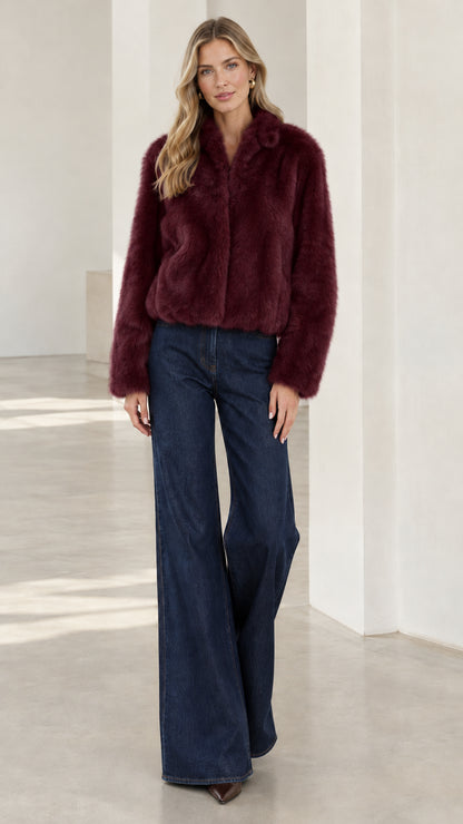 Model wearing rich burgundy cropped faux fur jacket with dark jeans