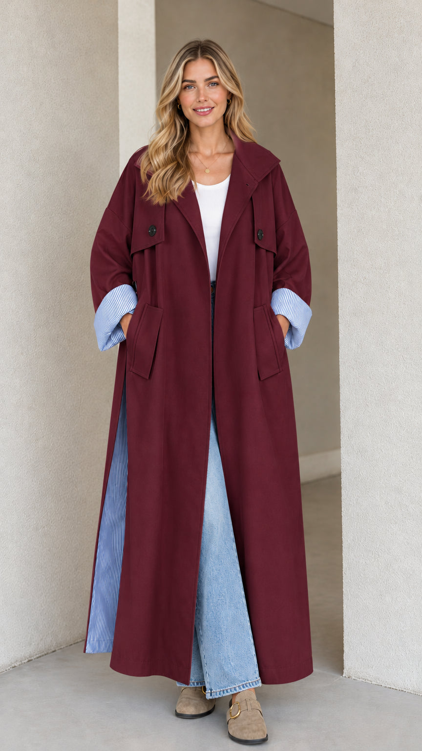 Front view of burgundy long duster trench coat with striped lining detail