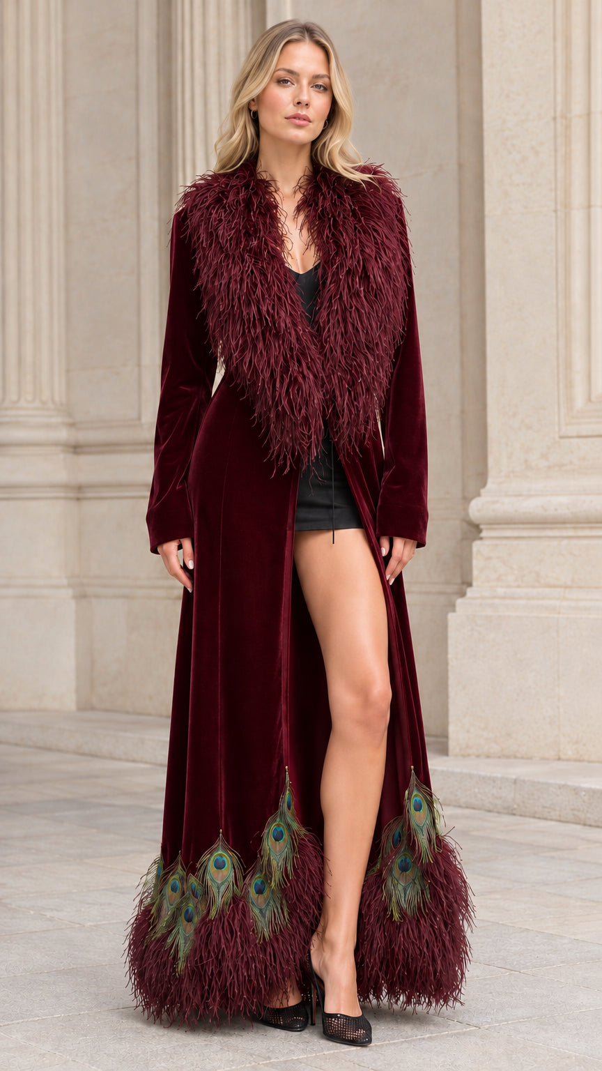 Model wearing burgundy red velvet maxi coat with peacock feather hem