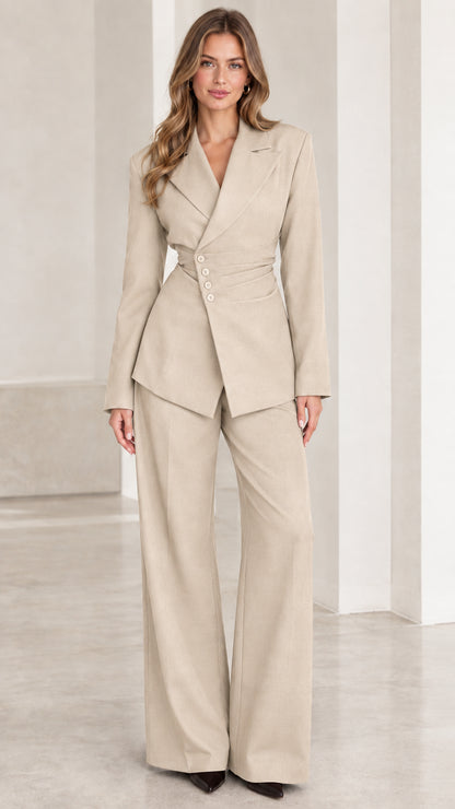 Front view of woman wearing beige tailored asymmetric blazer and wide-leg trouser set